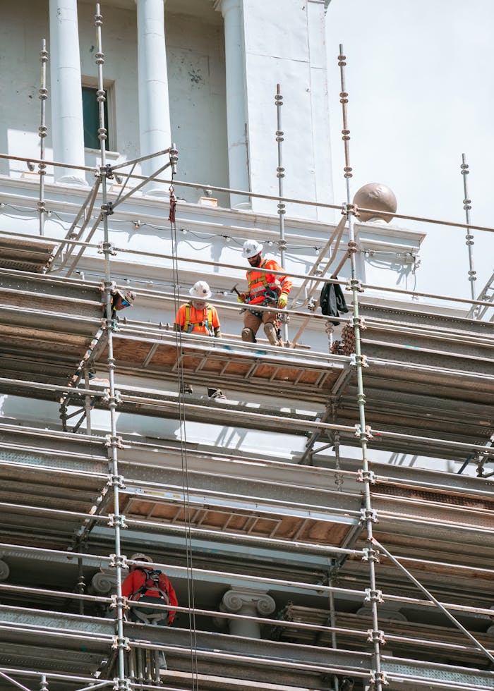 Construction workers on scaffolding at an urban renovation site in San Francisco.