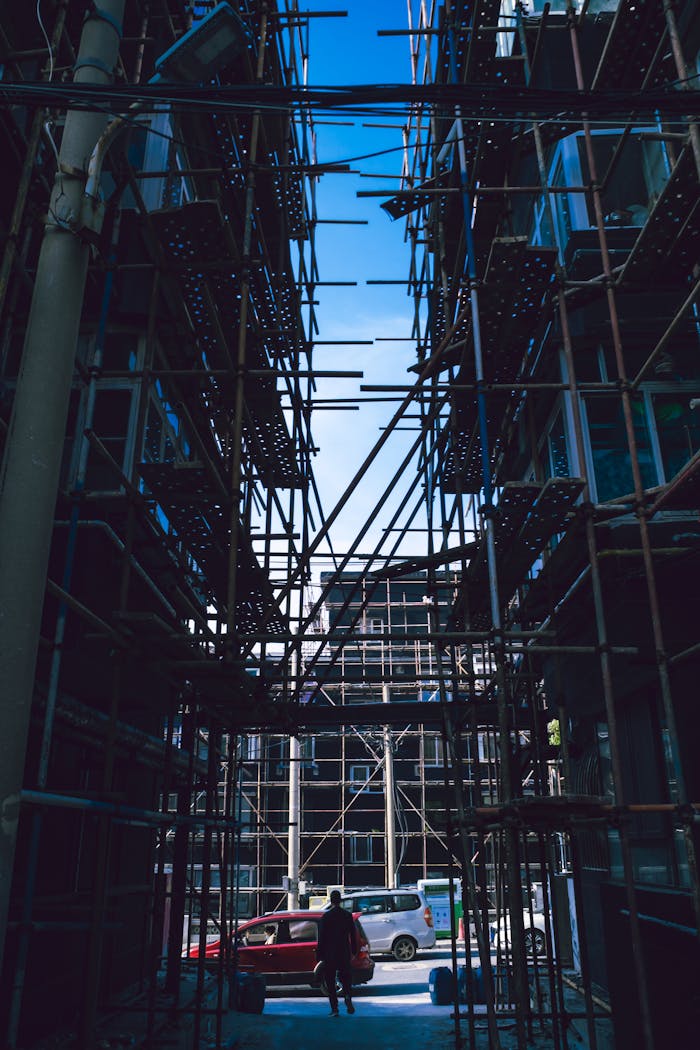 Silhouette view of urban construction site with scaffolding and city street backdrop.
